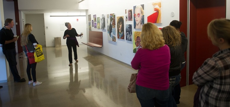 Woman showing gallery of artwork.
