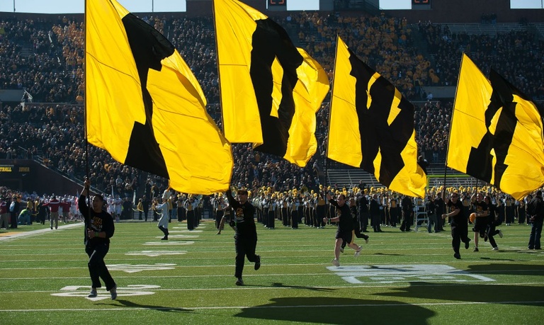 IOWA flags lead the team out of the tunnel