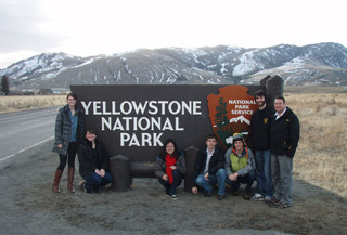 University of Iowa students standing beside a Yellowstone National Park sign