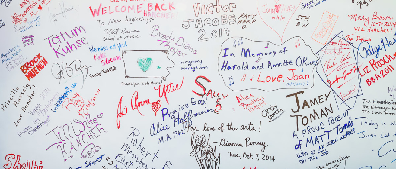 A white background with colored writings, including signatures and drawings made in marker