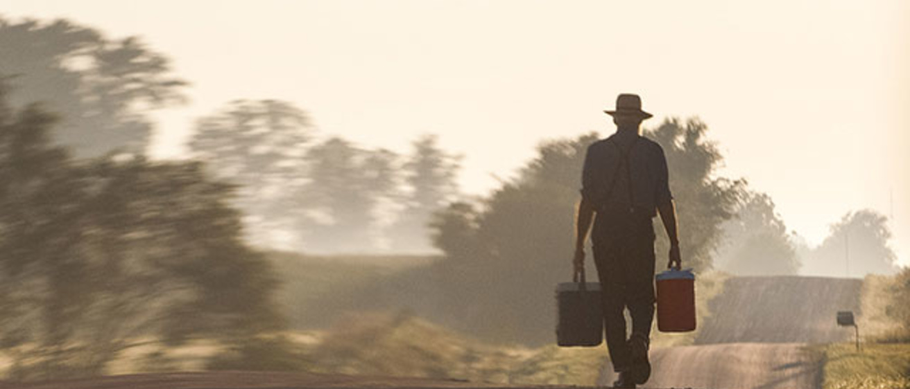 Amish man walking on a dirt road
