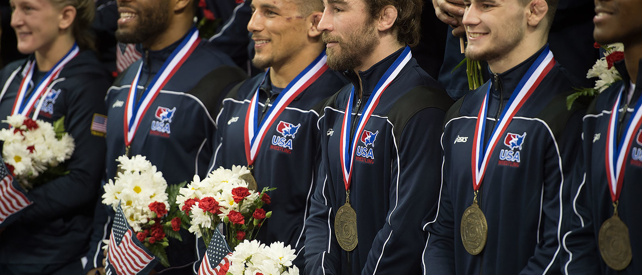 Daniel Dennis is surrounded by his Olympic teammates during the official team photo following the competition on Sunday.