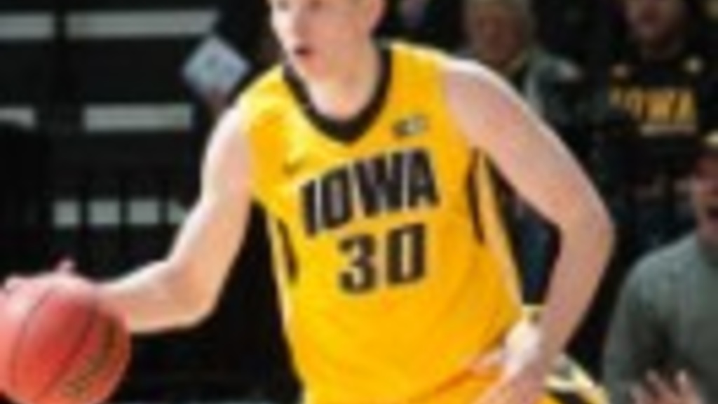 Image of UI basketball player Aaron White dribbling the ball