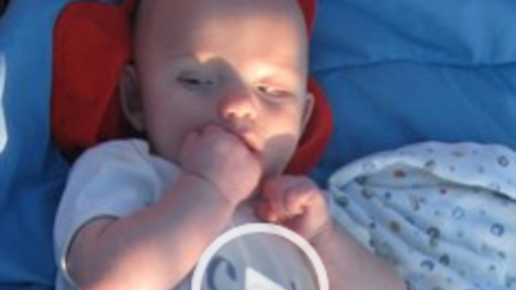 a screen shot of a video that has a baby sucking its hand