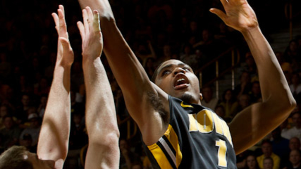 Iowa basketball player Melsahn Basabe (1) reaches for a layup with the ball in his extended right hand as Dayton player Matt Kavanaugh (35) attempts to block, but is too low.