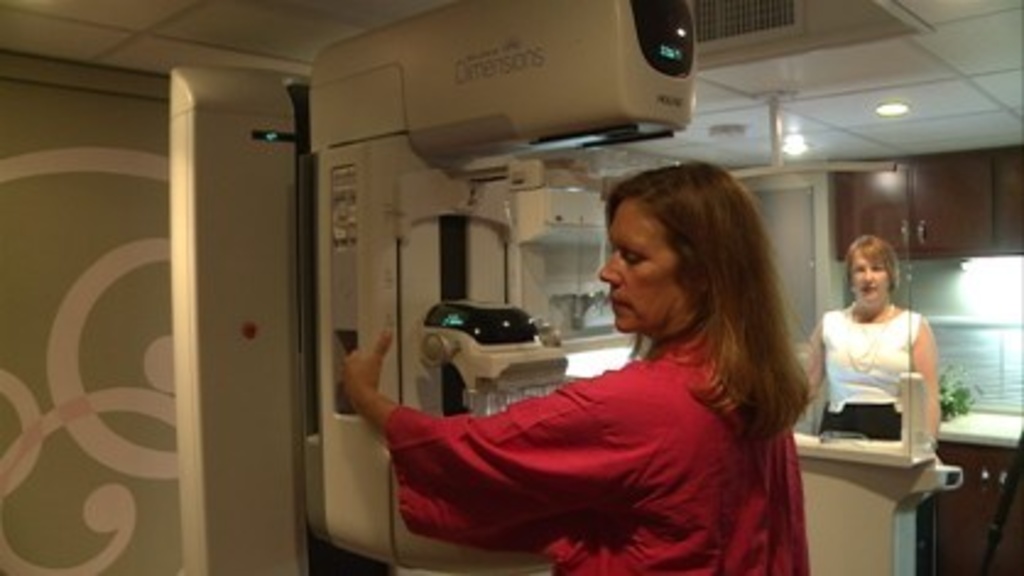 A woman demonstrates 3-Dt technology used to detect breast cancer early at UI Hospitals and Clinics