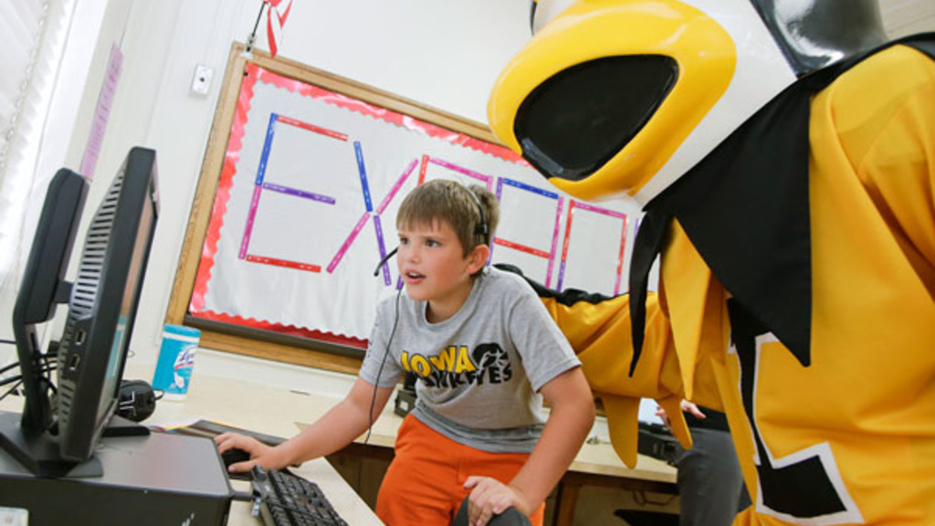 University of Iowa mascot Herky visits with Collin Wheat, 12, a seventh grader at Roosevelt Middle School as Collin shows what he has learned from the new software he has been using during an Iowa Center for Assistive Technology camp at the school Wednesd