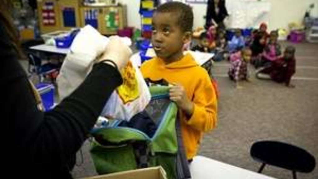Samuel Jedo, an Edmunds Elementary first-grader in Des Moines, picks up food to take home after school. / Rodney White/The Register