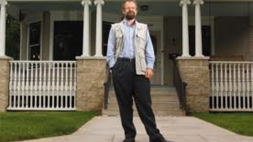 Christopher Merrill, director of the UI International Writing Program, stands in front of a house