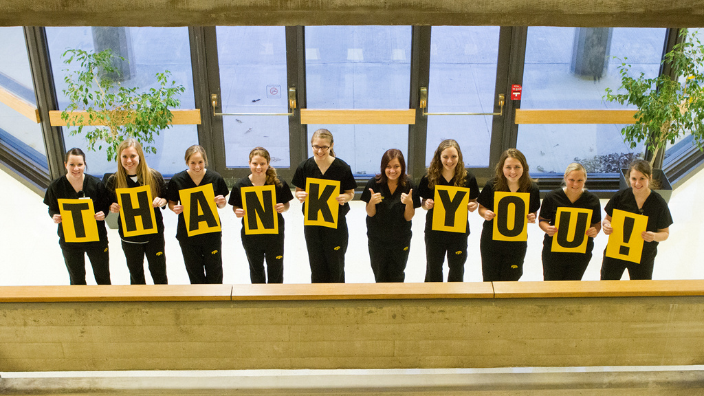 UI College of Nursing students hold up a thank you sign in front of the college.