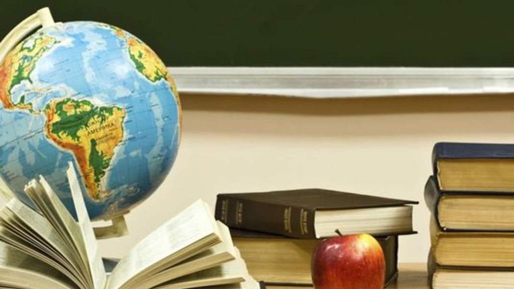 desk with books, apple, globe