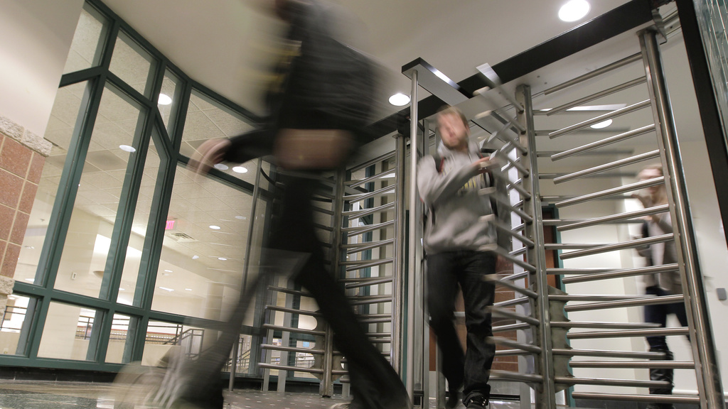 University of Iowa students file through turnstiles as they leave the residents&#039; areas of Burge Residence Hall on Monday. (Jim Slosiarek/The Gazette)