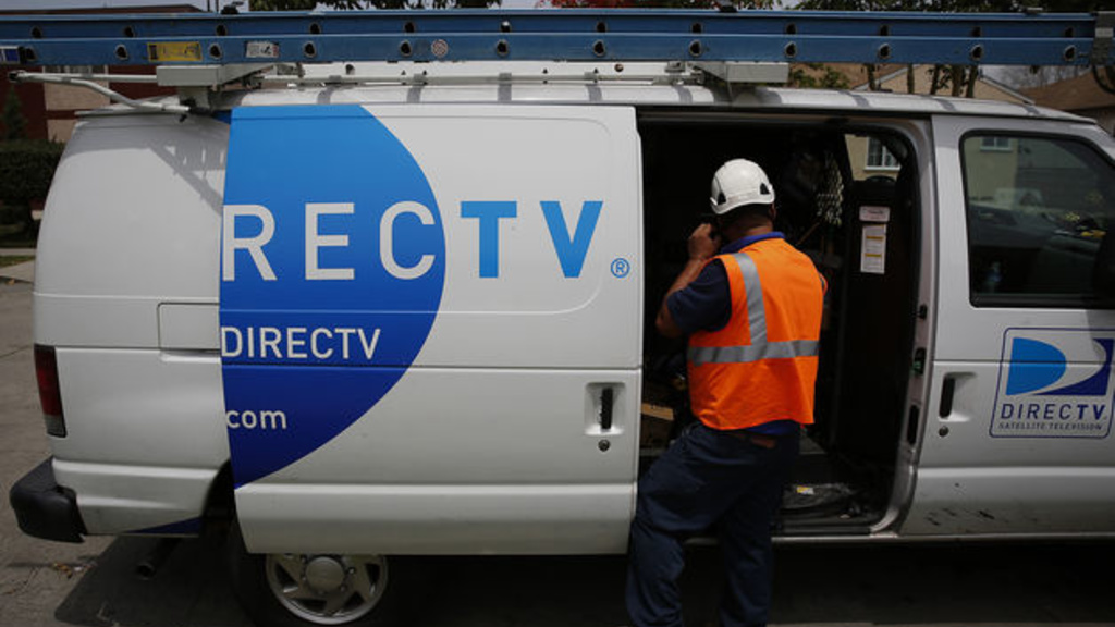An employee opens the door of a DirecTV van.