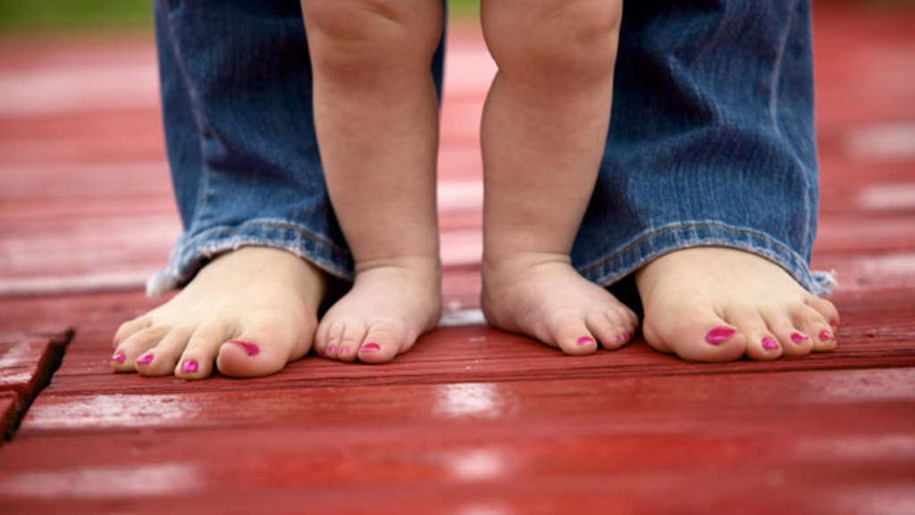 mom and baby's feet standing next each each other