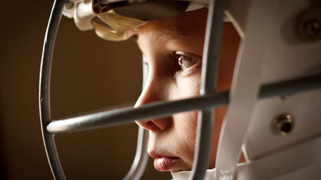 close up of a young boy wearing a football helmet