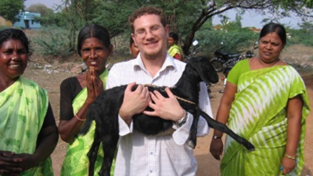 UI PhD student in geography Luke Juran, poses with several women while holding a goat during a Fulbright funded trip to India