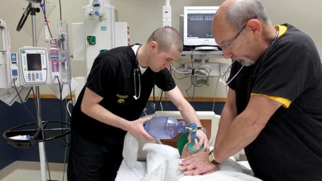 Dan Lose, left, and Frank Gedney work on a pretend patient at a nursing training facility at the University of Iowa Hospitals and Clinics on Friday. / Benjamin Roberts / Iowa City Press-Citizen PHOTOS