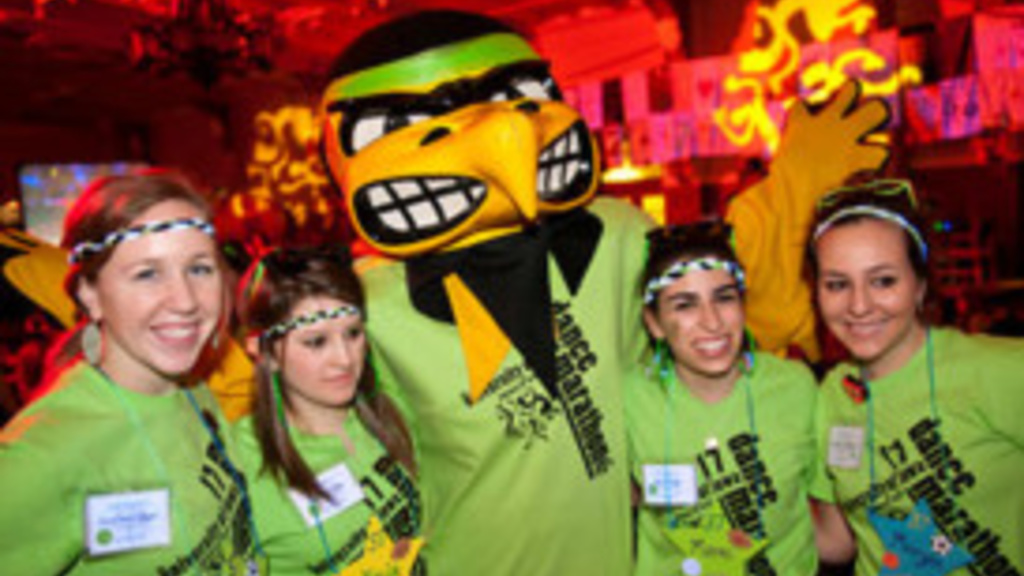 Photo of the UI mascot, Herky, surrounded by students participating in a past UI Dance Marathon