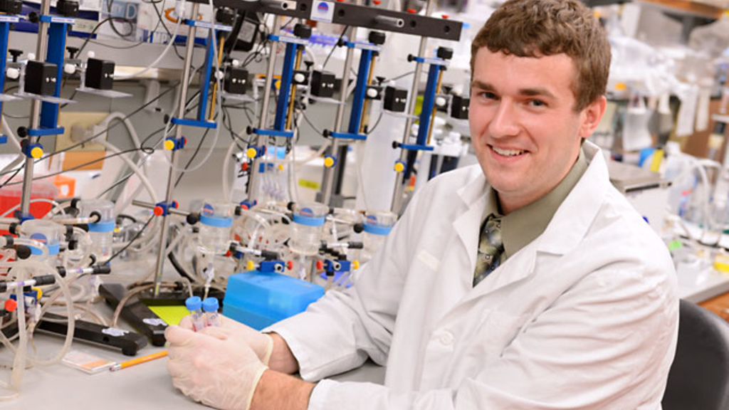 UI Student Employee of the Year, Andrew Michalski sits at a laboratory bench in the Eckstein Medical Researchh Building.
