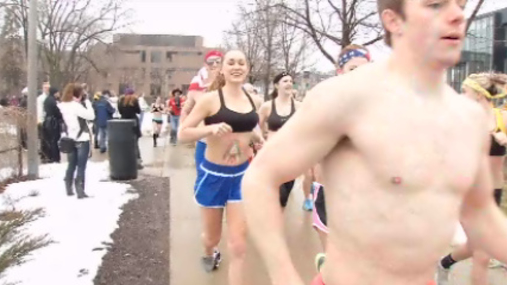 Students run nearly naked as part of the Near Naked Mile