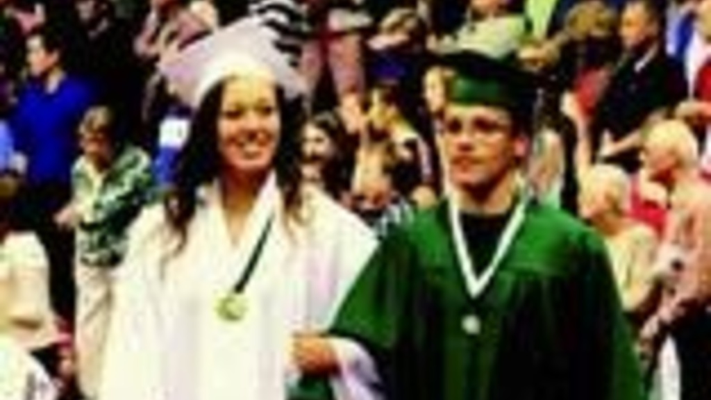 Pella student Lucas Rietveld in his high school graduation cap and gown with a female student also in cap and gown.