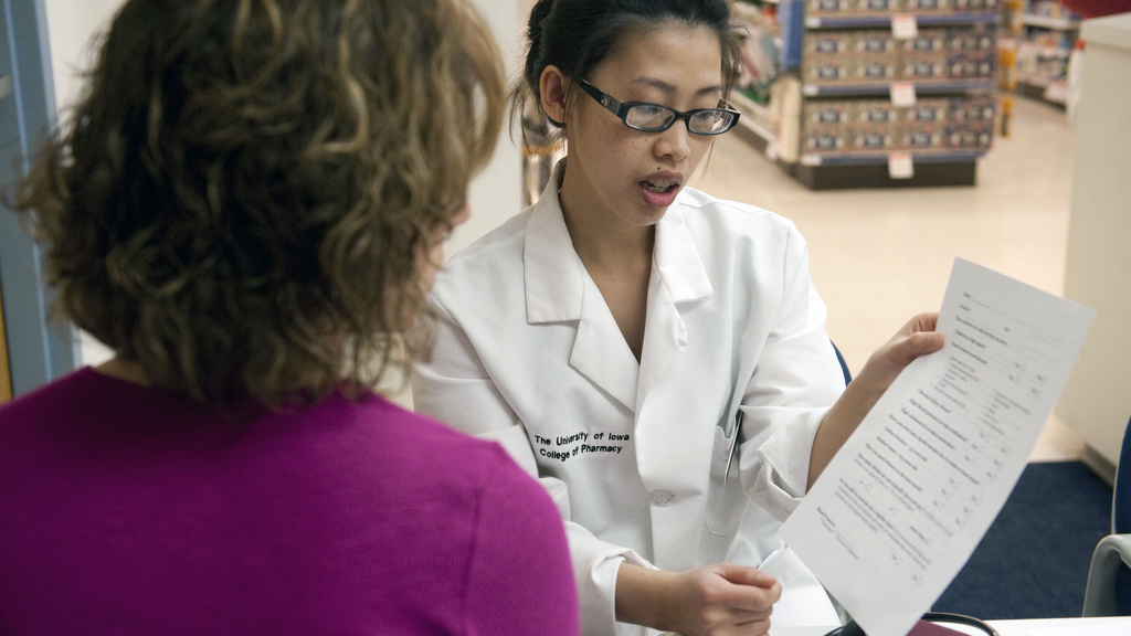 A University of Iowa College of Pharmacy student helps someone with information