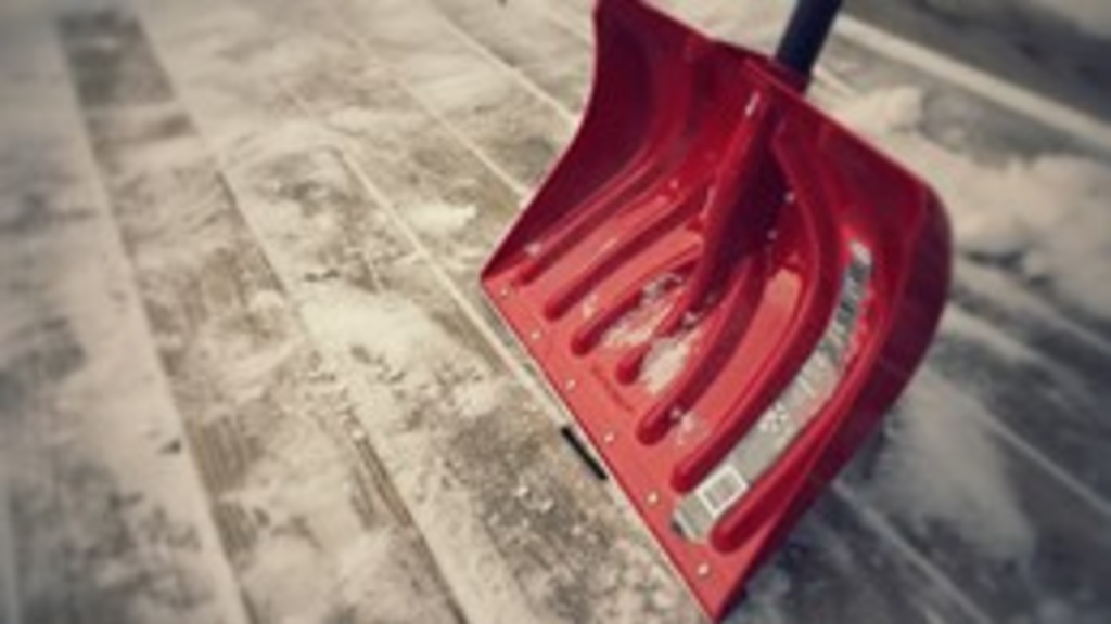 A red shovel moving snow