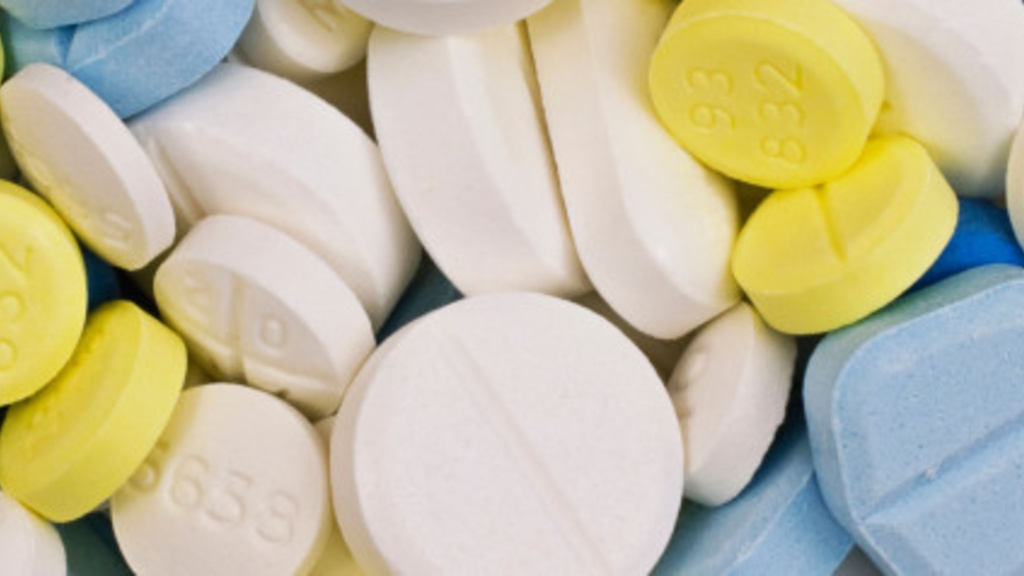 Close up image of white, yellow, and blue anti-psychotic pills