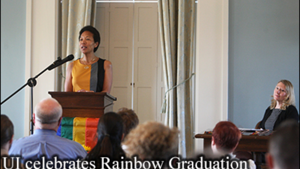photo of Dr. Georgina Dodge speaking at the podium in the Old Capitol Senate Chambers during the UI Rainbow Graduation