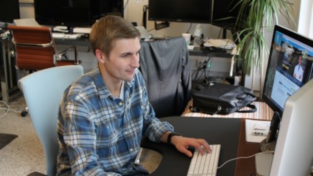 UI alumnus Rody Miller works at a computer to help with a new startup telepharmacy business to serve rural Iowans