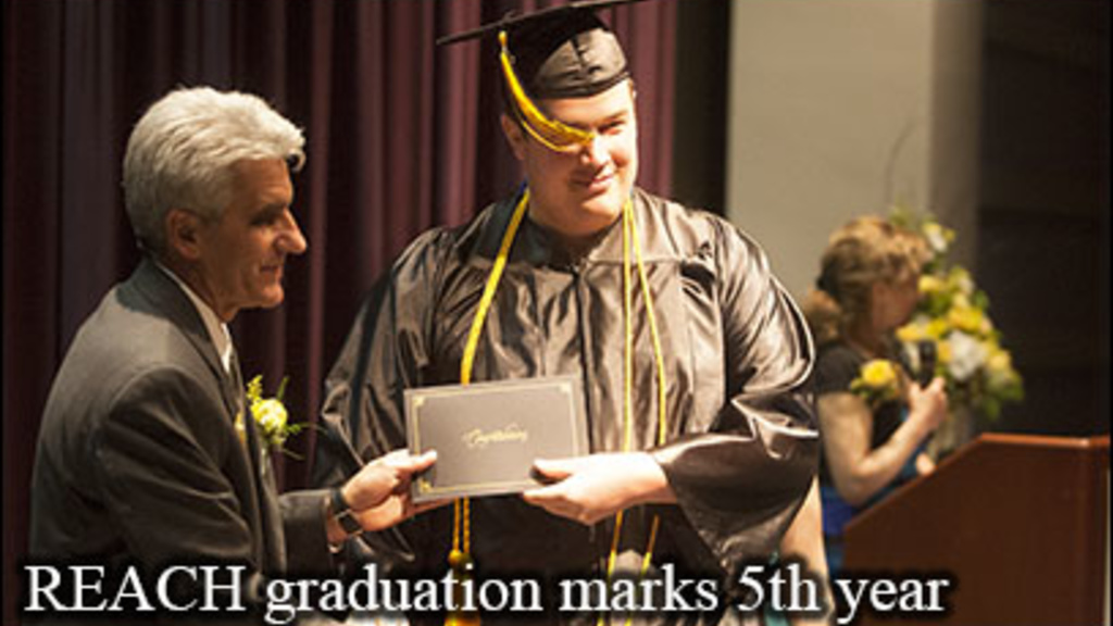 A graduate of the REACH Program accepts his diploma from Nick Colangelo, interim dean of the UI College of Education