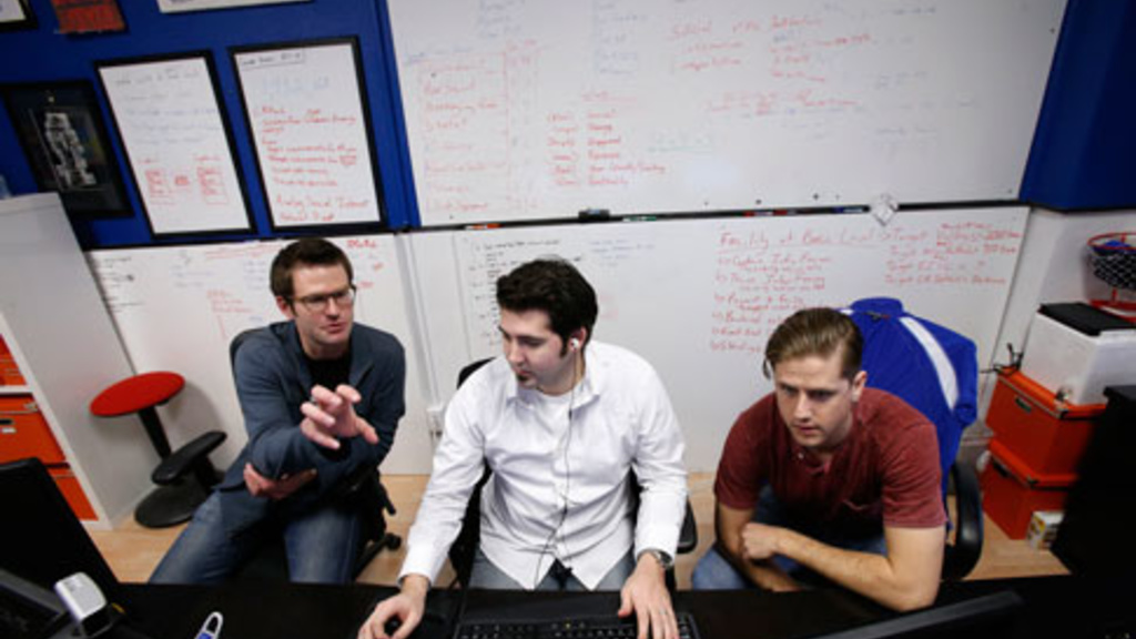 Three guys, Cofounder, CEO and quarterback John Schnipkoweit, (left), cofounder and commissioner of code Chris Quartier, cofounder and game master Nick Sihacek work in the office of RecBob in downtown Cedar Rapids. (Cliff Jette/The Gazette)