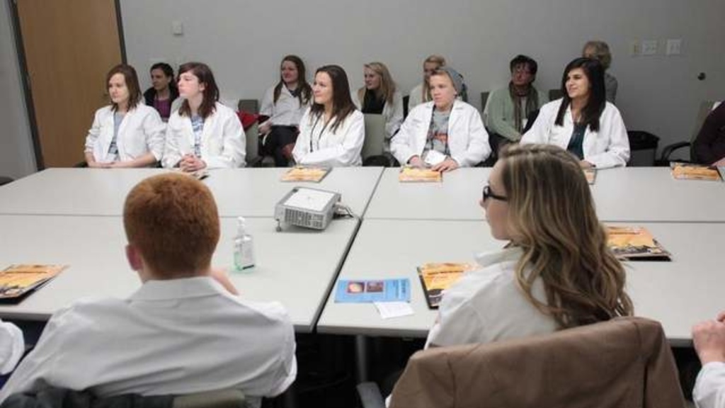 High school students listen to University of Iowa junior Sergio Loubriel during a presentation Thursday at the Medical Education and Research Facility. The session was one of numerous laboratory tours offered to students interested in pursuing a career in