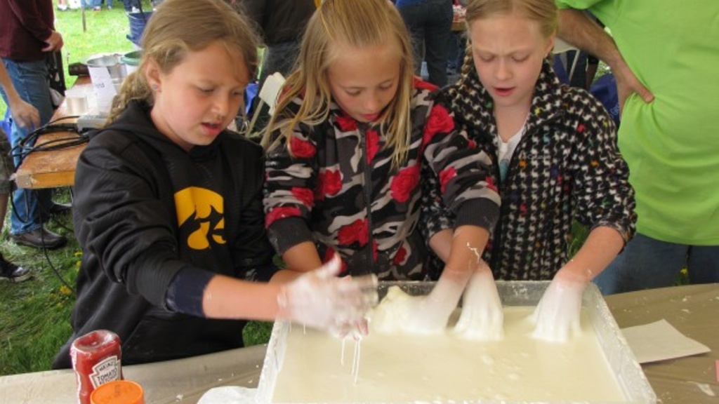 Elise Finn, 9, Aricka Ramser, 10, and Olivia Harmon, 10, all of Muscatine, discover what the oobleck feels like, which is liquid made of cornstarch and water