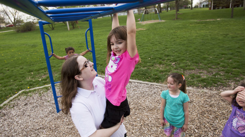 Brittany Honer helps her daughter, Kaitlin Ansell, 5, across the monkey bars at Jacolyn Park on Tuesday, May 7, 2013, in Cedar Rapids. A U.S. Census Bureau reports a big spike among unwed mothers in the 20 to 24 age range, which includes Honer, 22. (Liz M