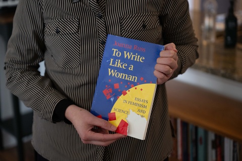 UI professor and author Paige Lewis holds a copy of "To Write Like a Woman"
