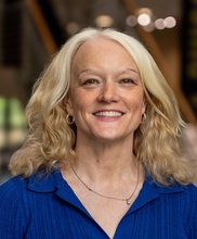 Mary Charlton, a woman with medium-length blonde hair wearing a blue shirt