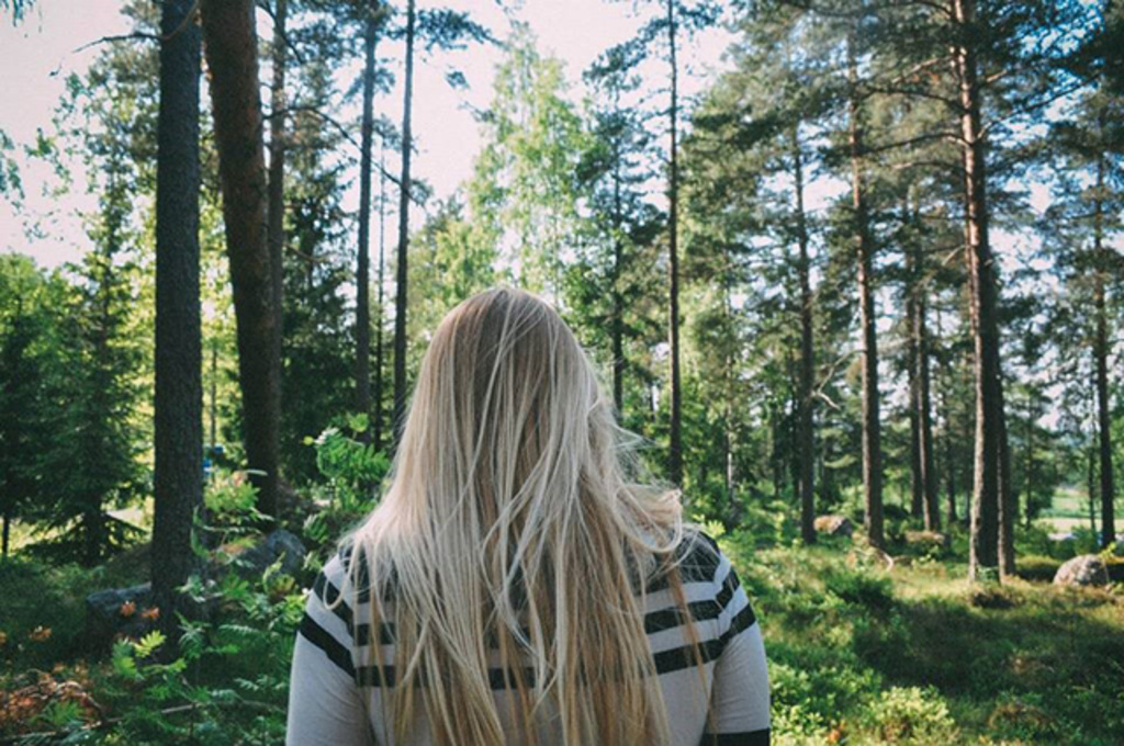 a girl walks through a forest in Sweden