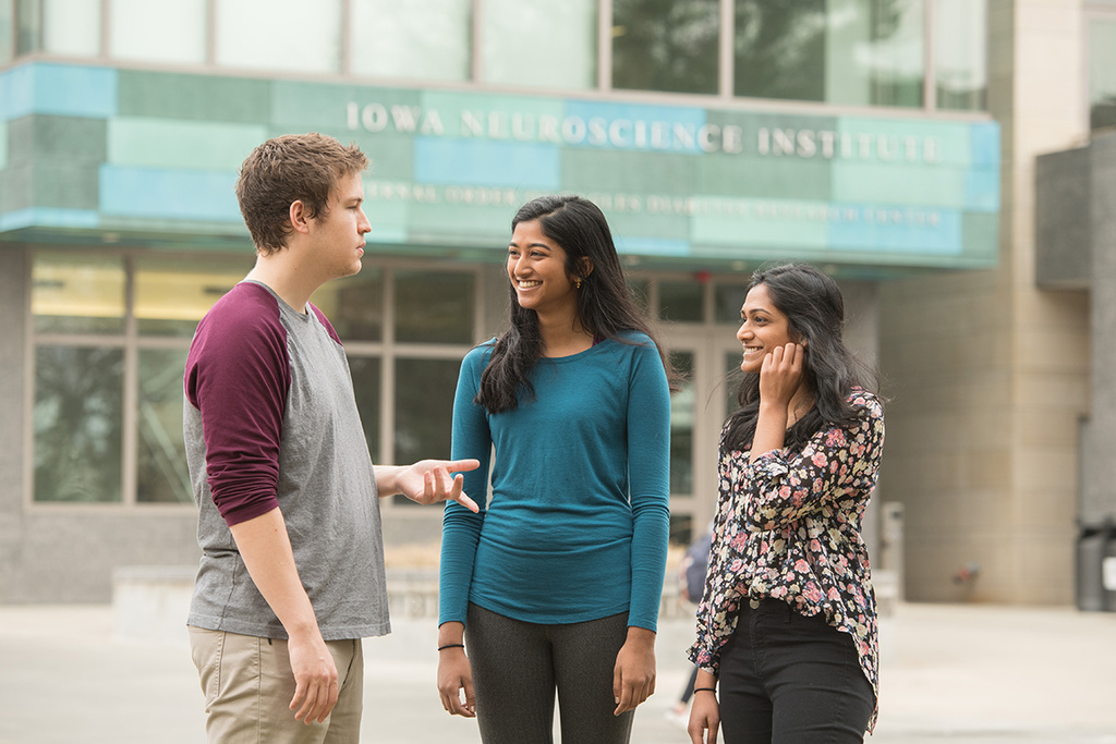 three undergraduate researchers conversing outside facility