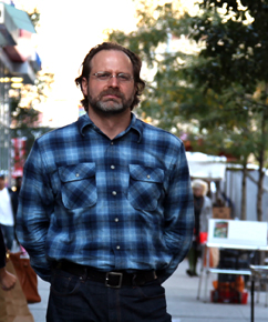 Photo of a bearded man in a blue flannel shirt