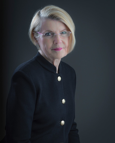 A photo portrait of a blonde woman with a black blouse.