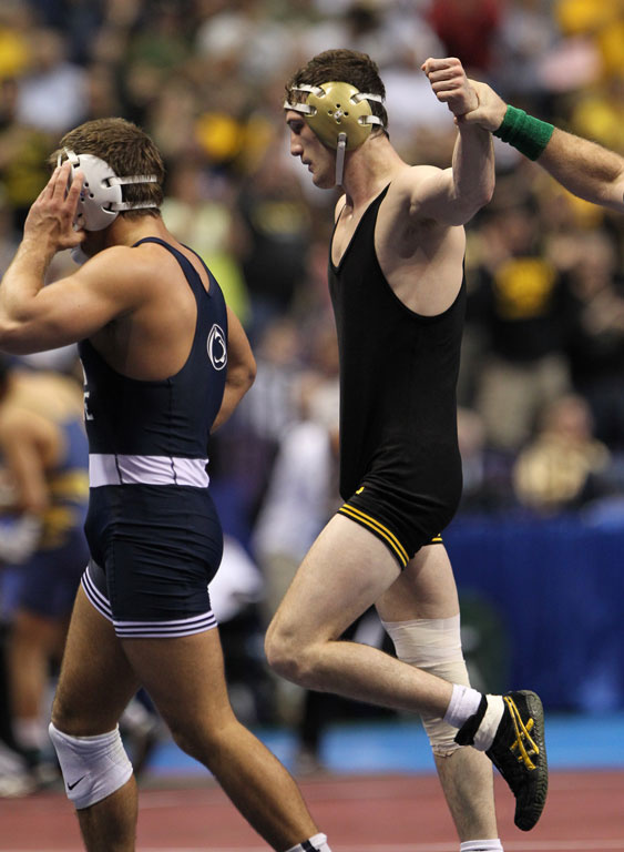 The referee raises Derek St. John's hand after a victory at the NCAA Championships. 