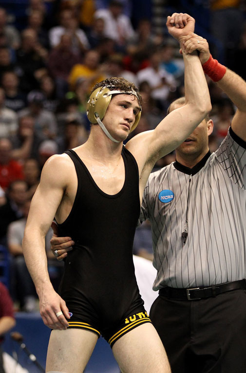 The referee raises Derek St. John's hand after a victory at the NCAA Championships. 