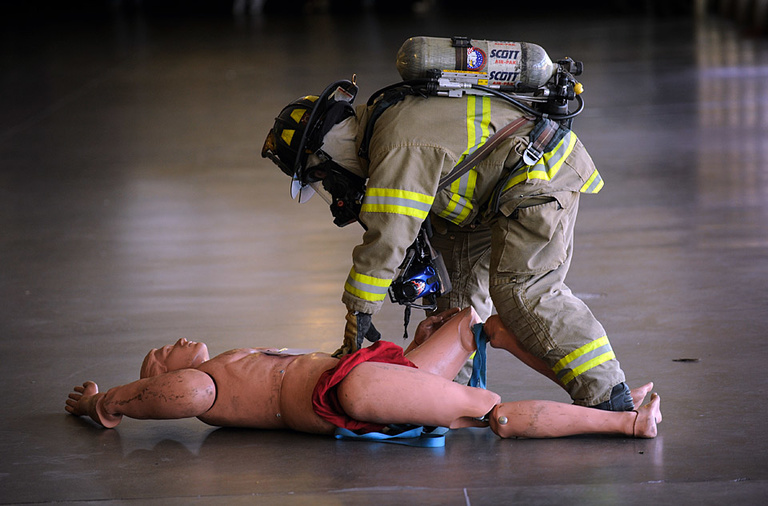 A firefighter examines a "dummy" victim.