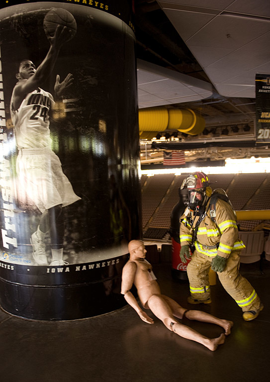 A firefighter examines a "dummy" victim.