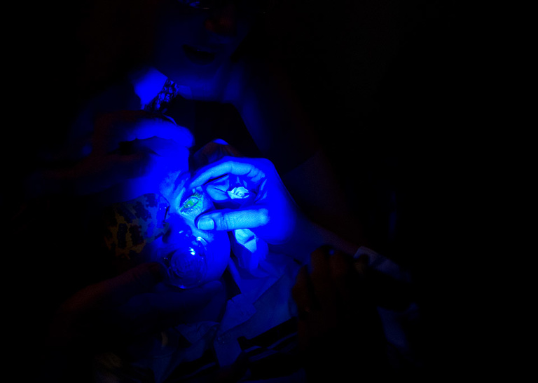 A blue light illuminates Christopher's eye.