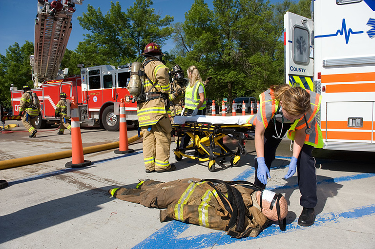 A dummy victim is examined by an EMT.