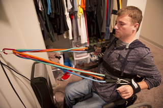 Travis strengthens his arms and shoulders with exercise bands.