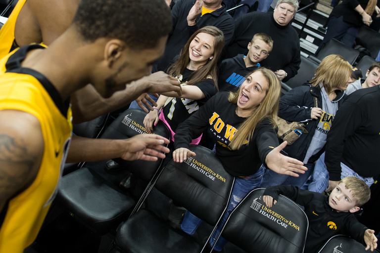 Young female fan sticks her hand our for a high-five from a player.
