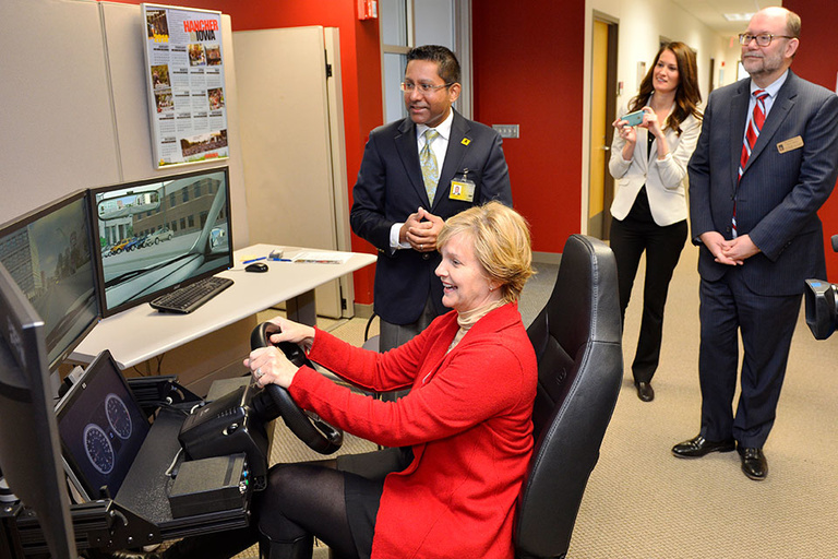 State Sen. Liz Mathis takes one of the mini-sims for a spin at the National Advanced Driving Simulator Thursday while others look on.